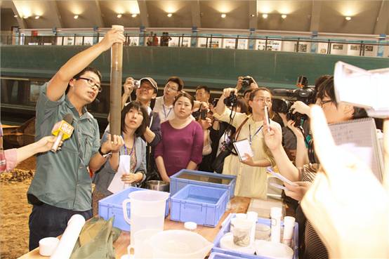 图为:考古人员在“南海1号”古沉船上为各家新闻记者讲解试掘情况。(记者 王成宝摄)